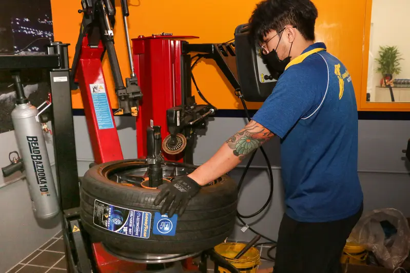 ▲ 技師熟練地操作半自動拆胎機，將固特異ElectricDrive裝進鋁圈。