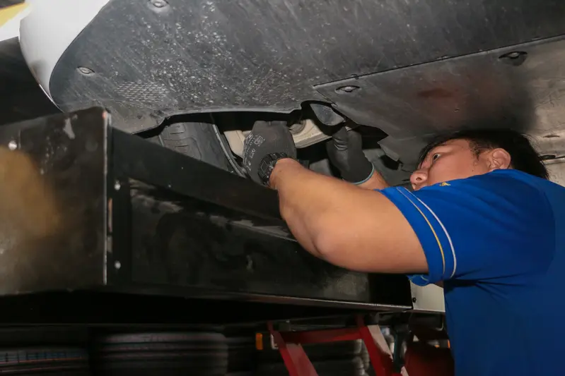 ▲ 技師在底盤下方調整前束角與後傾角。