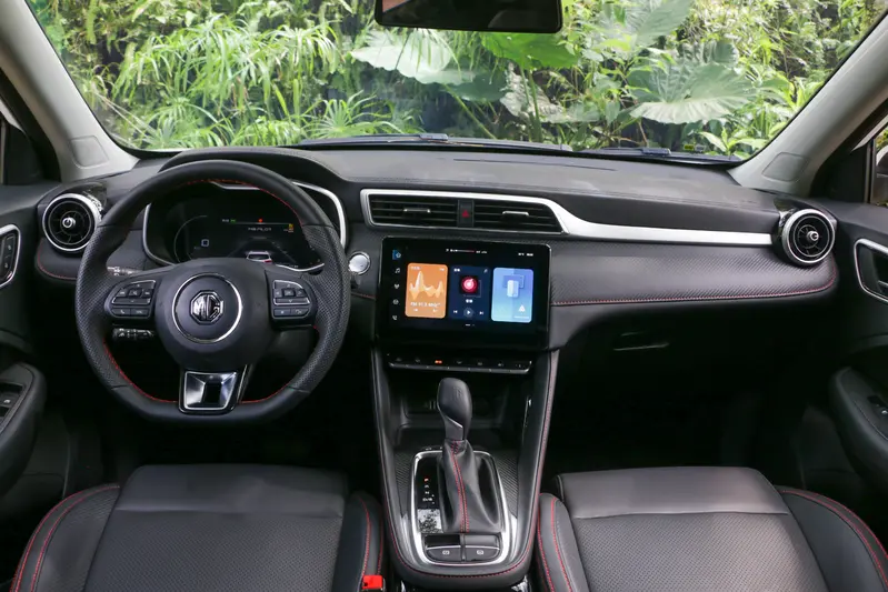 ▲全新 2027 年式MG ZS 中控台使用霧銀飾條、類碳纖維飾板、亮黑色飾板堆疊,搭配隨處可見的紅色縫線,有著傲視同級的車艙質感。