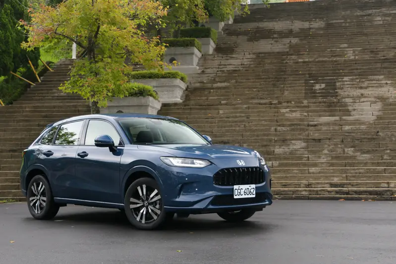 ▲ZR-V e:HEV 刻意採用同級距中少見的低重心車格設定；若湊近細細品味，更能發現原廠設計師從引擎蓋一路延伸至車身腰線，皆貫徹了極為優雅的水平基準線調性。搭配一路延展的長車頂線條設計，在視覺路感上塑造出比數據記載更加低趴、貼地的俐落姿態。這種打破常規的幾何設計，不僅成功消弭了傳統休旅車常見的笨重感，更在靜止間隱隱宣示著其傲視同級的動感跑格。